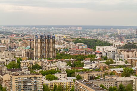 Cityscape with multiple high-rise and residential buildings under cloudy sky