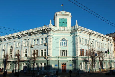 Large historic corner building with multiple floors and a small tower on the roof
