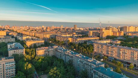 Moscow city in yellow sun at dawn timelapse. Life in the stone jungle. Early foggy morning. Shadows moving on houses. Megalopolis aerial panoramic view from rooftop at Leninskiy avenue